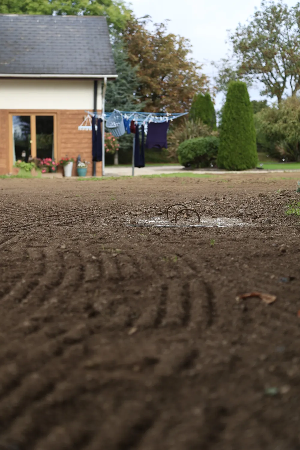 Newly graded garden soil with a house in the background