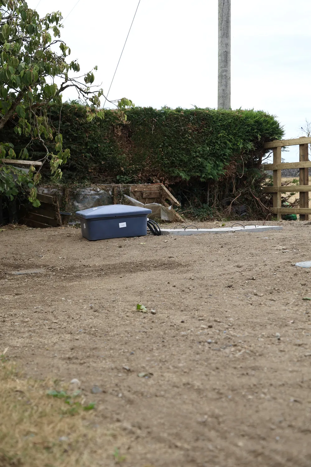 Freshly graded garden beside a timber fence and hedge