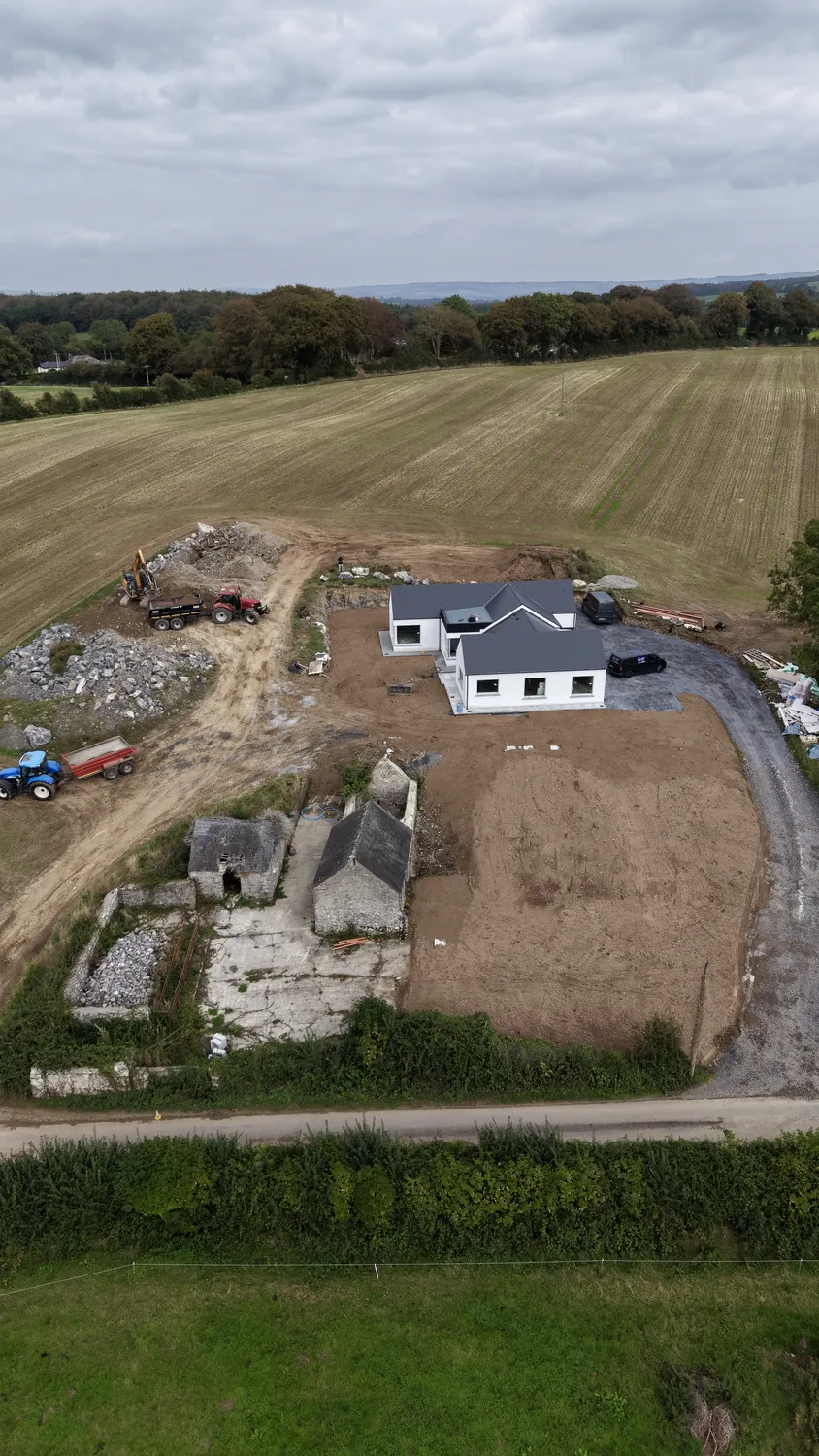 Aerial view of a house and surrounding cleared and graded ground