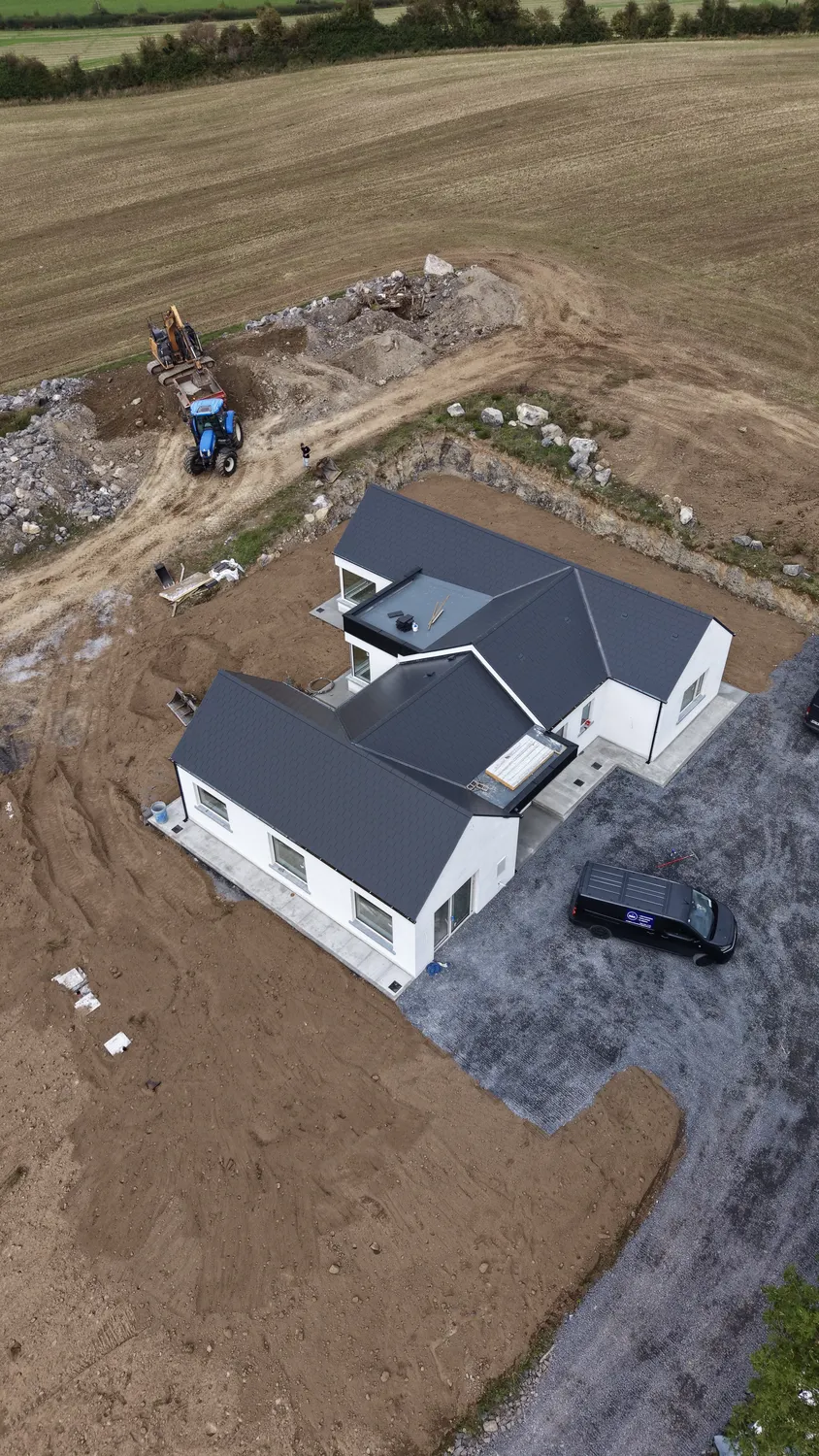 Aerial view of earthworks and stone areas around a newly built home