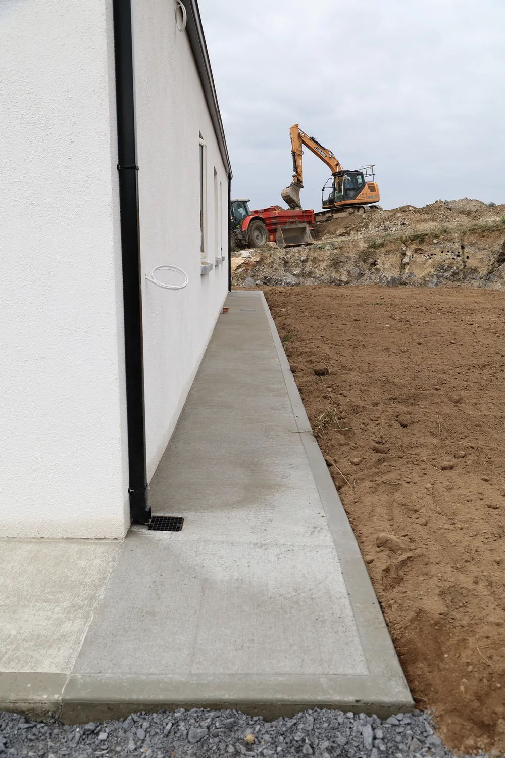 Fresh concrete walkway alongside a newly built house