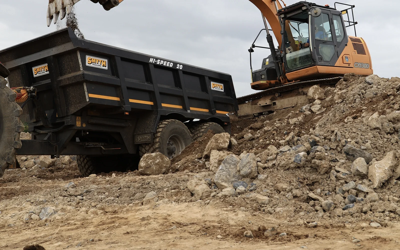 Excavator and dumper removing rubble during demolition and site clearance works