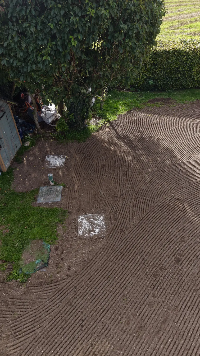 Aerial view of a home and surrounding prepared garden plot
