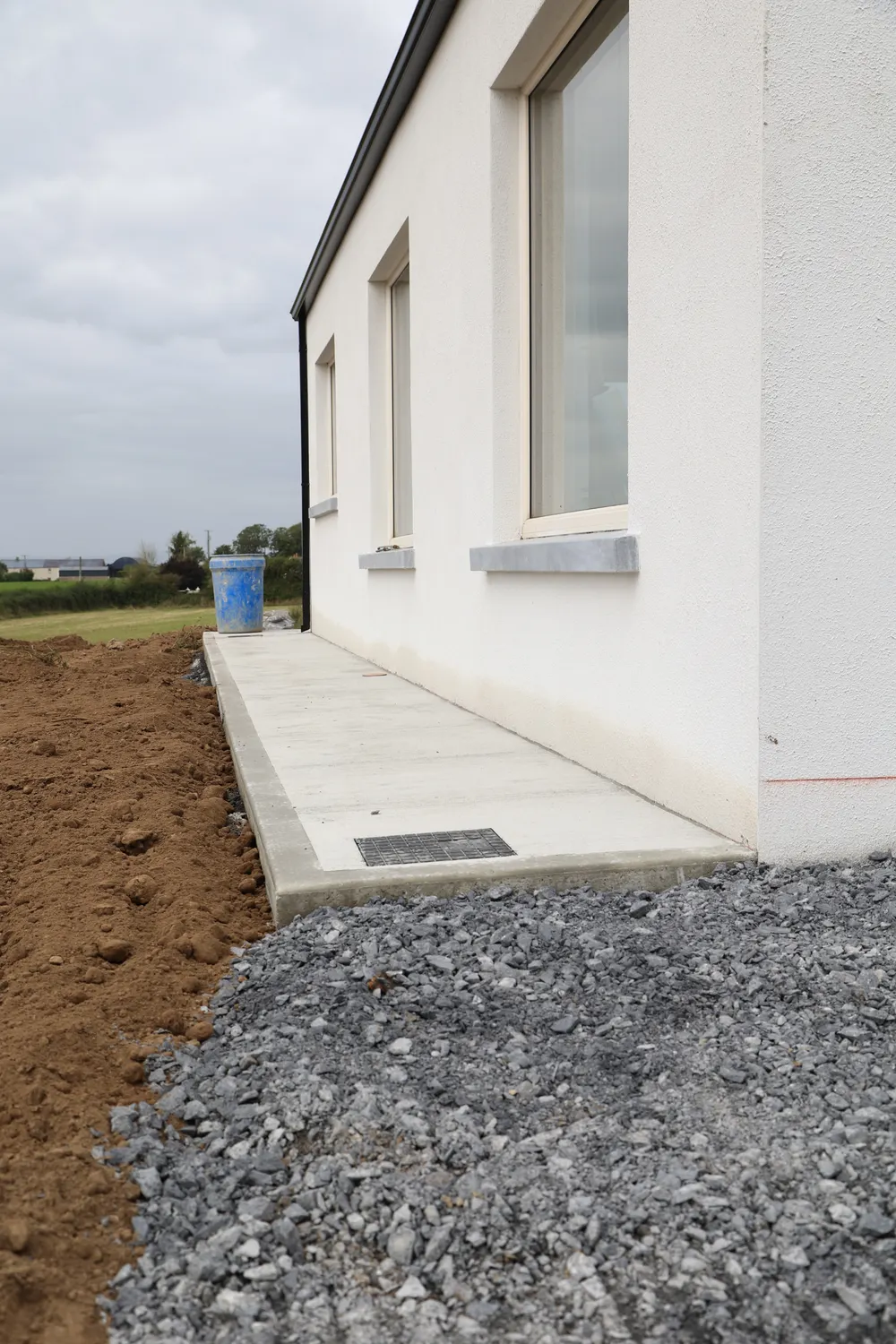 Gravel and drainage channel alongside a new house