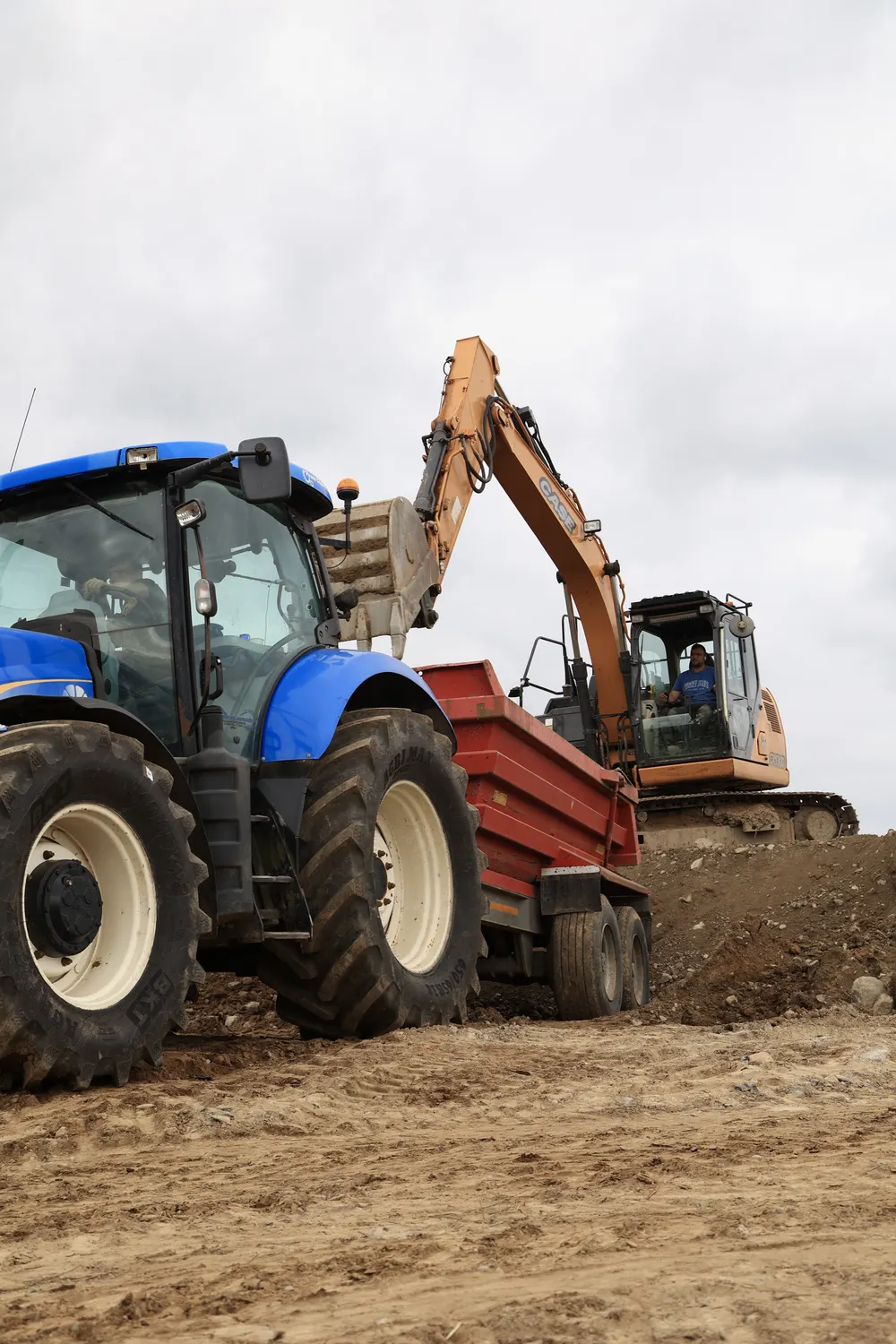 Tractor and excavator working together on a cleared site
