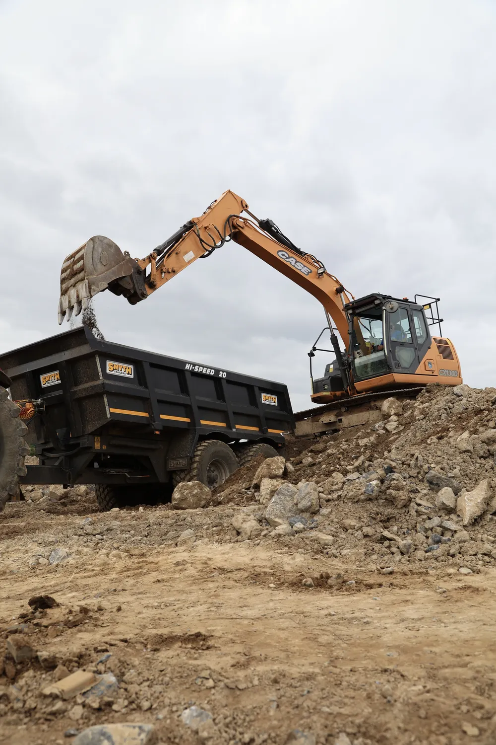 Excavator loading a tipper lorry with excavated earth