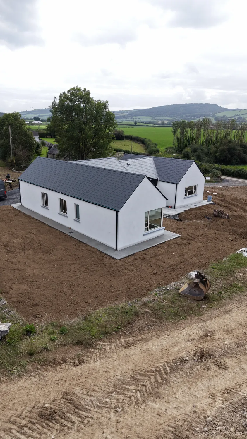 Aerial view of a new home with earthworks across the surrounding plot