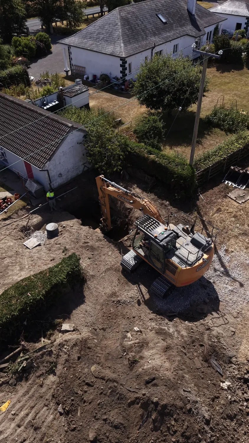 Aerial view of an excavator working next to a house