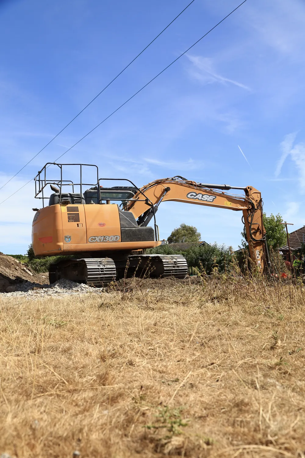 Excavator standing on rough ground before site clearance