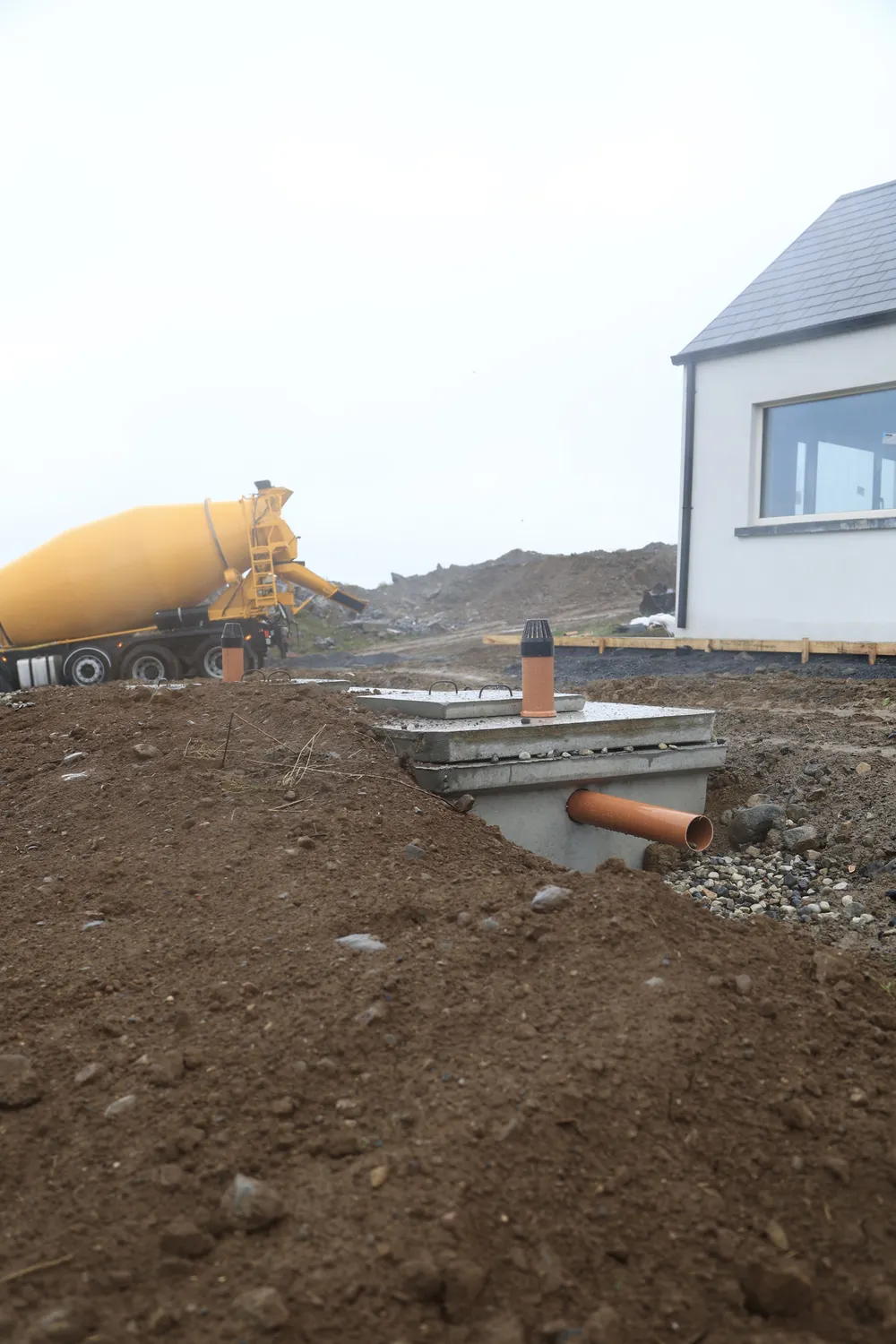 Excavated ground and drainage works alongside a new house