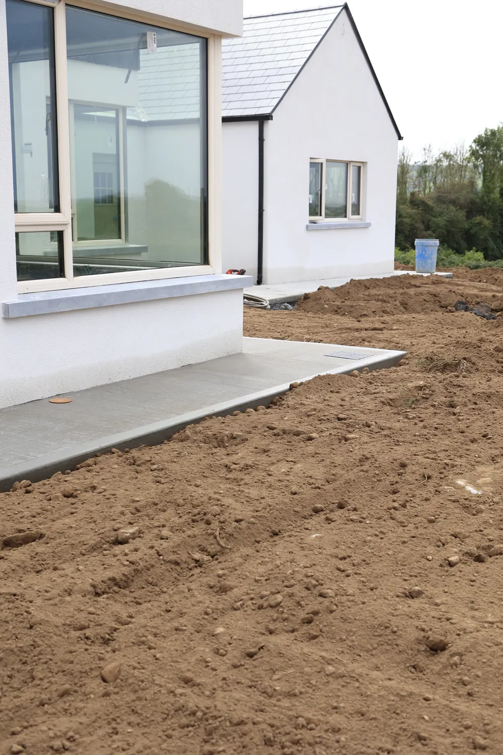 Concrete paths and graded soil around a newly built house
