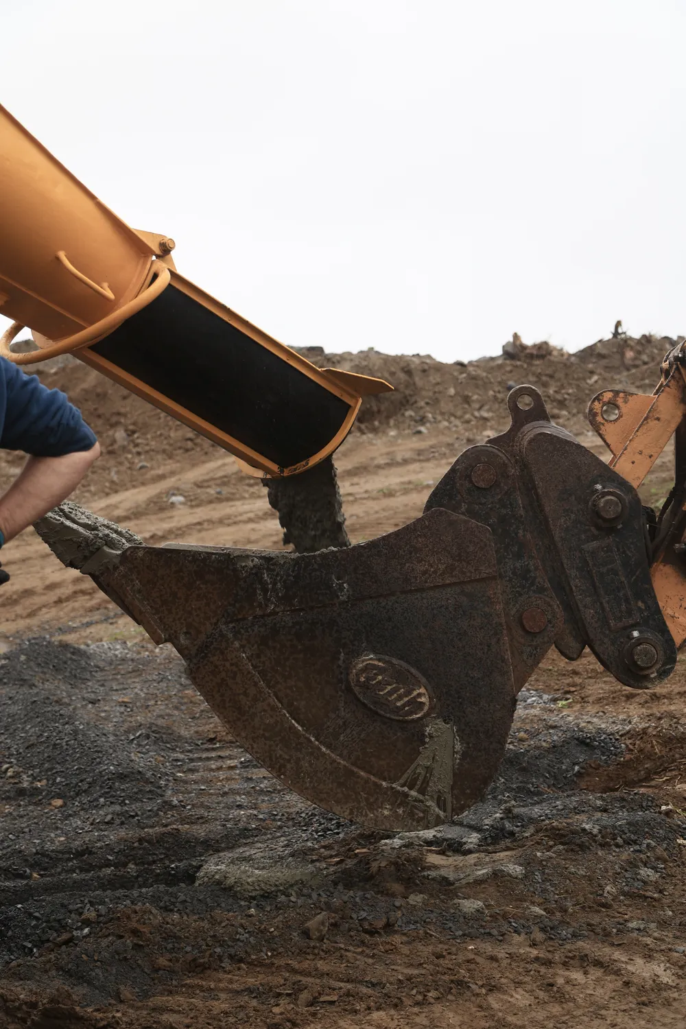 Close-up of an excavator bucket moving soil on a construction site