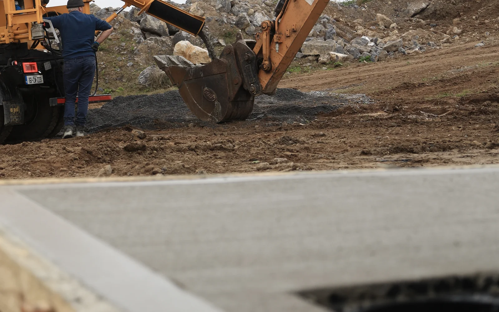 Excavator working beside newly poured concrete foundations on a house site in Carlow