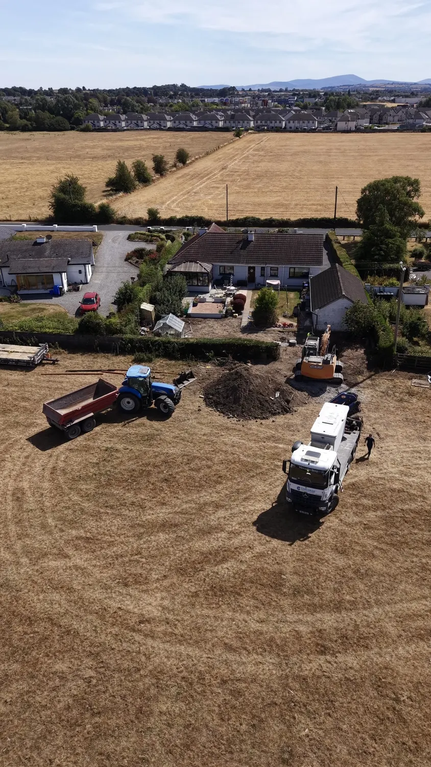Overhead view of equipment and groundwork beside an existing house
