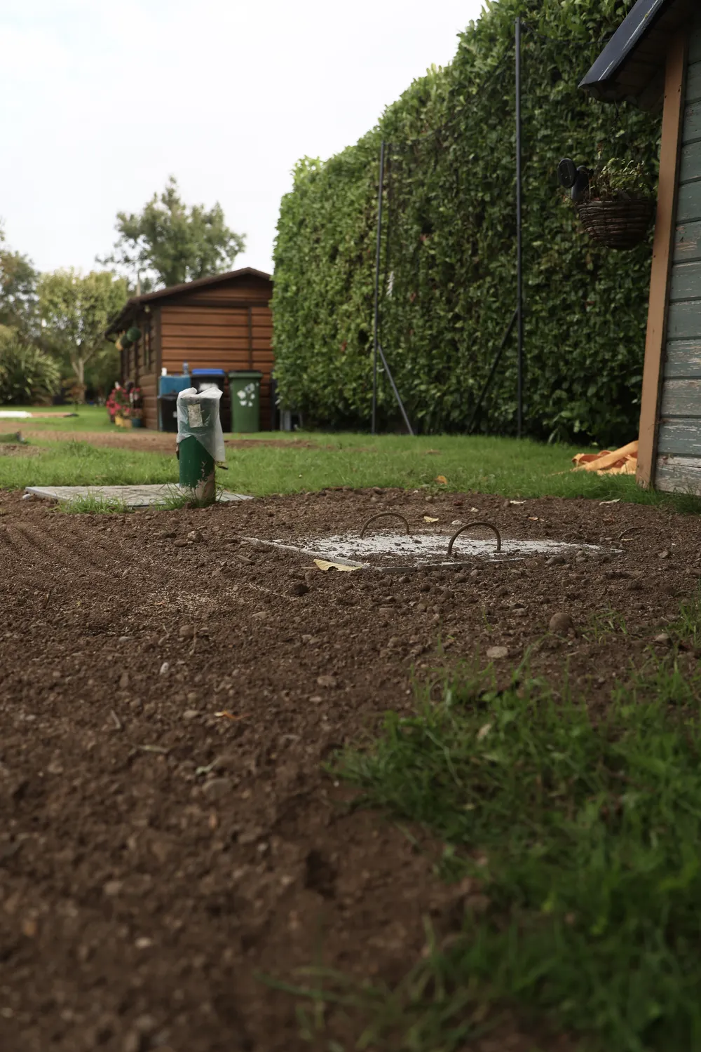 Furrowed soil across an open garden with fields beyond