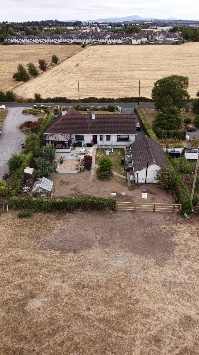 Aerial view of levelled soil in front of an existing house