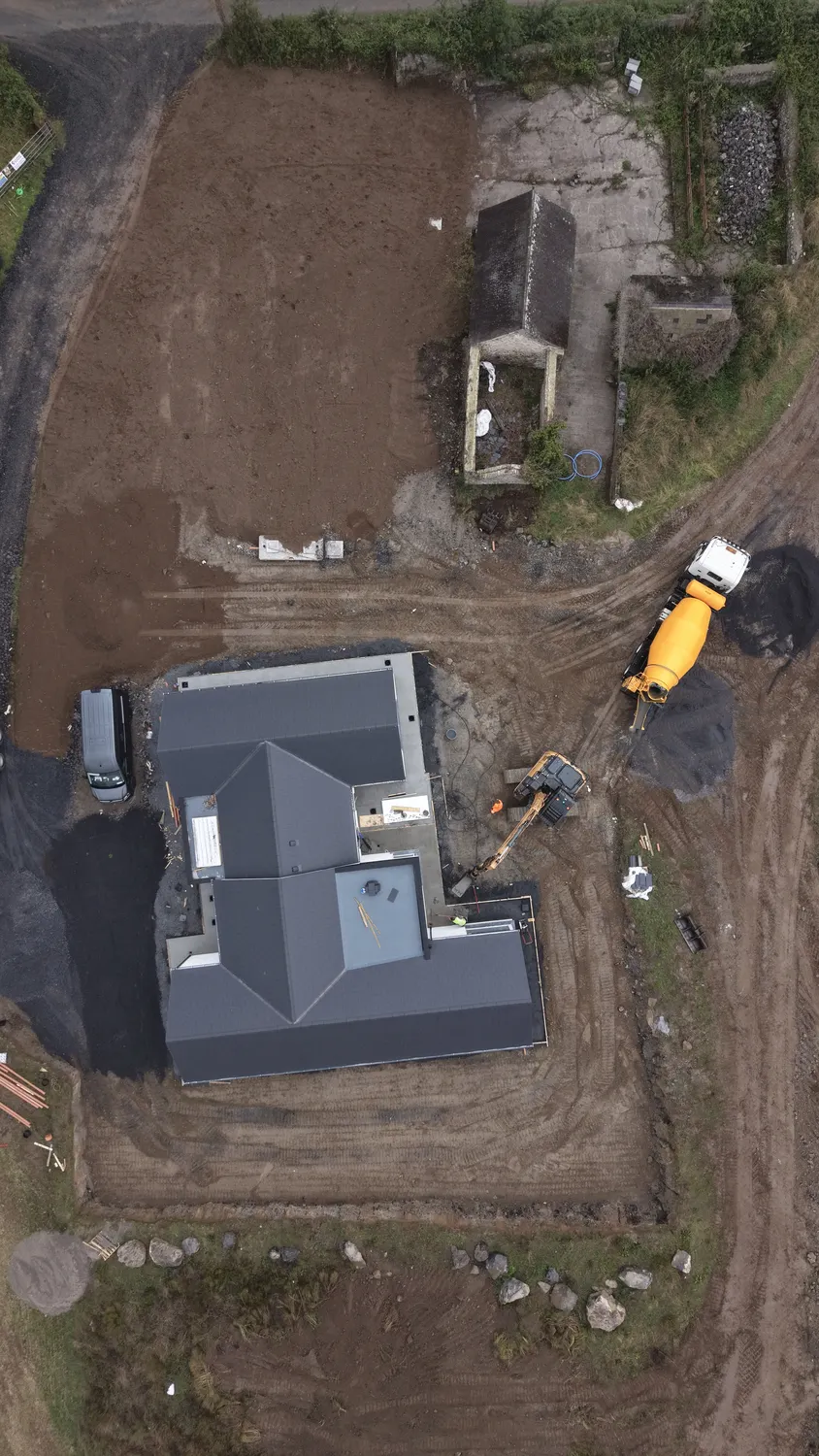 Overhead view of graded ground and machinery beside a new home